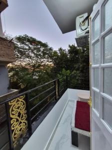 a balcony with a window and a red rug at Thebes Guest house in Jazīrat al ‘Awwāmīyah