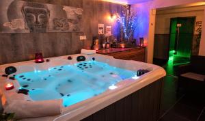 a jacuzzi tub in a bathroom with purple lighting at Ô Spa Champenois in Écueil +30 photos