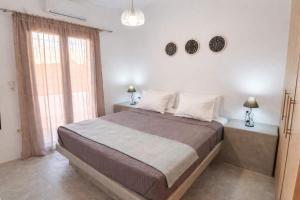 a bedroom with a large bed and a window at Villa Therme Athen - Sea View Jacuzzi Santorini Stay in Emporio