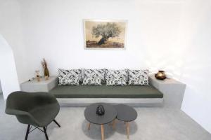 a living room with a green couch and a chair at Villa Therme Athen - Sea View Jacuzzi Santorini Stay in Emporio