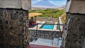 a house with a swimming pool with a mountain in the background at Eagle Nest lake Natron Lodge in Mtowabaga