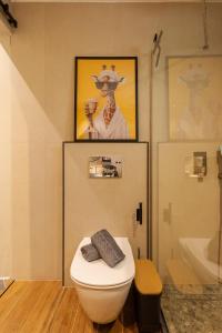 a bathroom with a toilet and a picture of a giraffe at Kálos Housing - Adults Only in Kolymbia +46 photos
