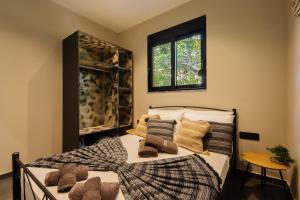 a bedroom with a bed with pillows and a window at Kálos Housing - Adults Only in Kolymbia