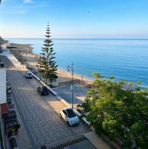 two cars parked on a street next to the ocean at La Finestra Sul Mare in Torretta