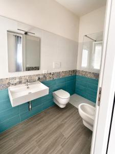 a bathroom with a white sink and a toilet at La Finestra Sul Mare in Torretta