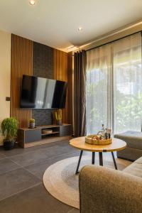 a living room with a tv and a coffee table at Kálos Housing - Adults Only in Kolymbia