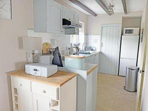 a kitchen with white cabinets and a white microwave at The Old Barn-E1425 in Addlethorpe