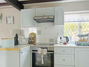 a kitchen with white cabinets and a stove top oven at The Old Barn-E1425 in Addlethorpe