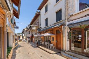 an empty street with buildings and tables and chairs at Petit cocon cosy en hyper centre in Villard-de-Lans