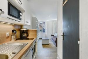a small kitchen with a sink and a microwave at Petit cocon cosy en hyper centre in Villard-de-Lans