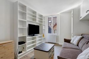 a living room with a couch and a tv at Petit cocon cosy en hyper centre in Villard-de-Lans +13 photos