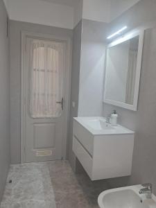 a white bathroom with a sink and a mirror at Centric 2 bedrooms Apartment near to the beach - newly renovated bathroom and bedrooms - by TENERIFEHINTS in El Médano +19 photos