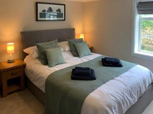 a bedroom with a bed with two towels on it at Lantern Cottage in Lyndhurst +10 photos