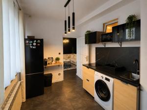 a kitchen with a black refrigerator and a dishwasher at Sleep Good by Adria 