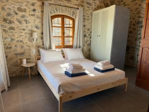a bedroom with a large bed with towels on it at Stone Villa, Infinity Pool & Libyan Sea Views in Agia Galini +43 photos