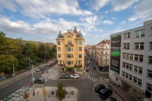 a yellow building in a city with cars on a street at Czech Inn in Prague