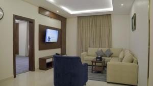 a living room with a couch and a tv at نزل خيال جيزان in Jazan