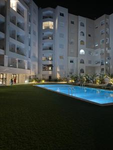 a swimming pool in front of a building at night at rental per night in Nabeul