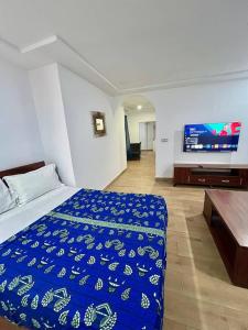 a bedroom with a bed and a flat screen tv at Tchaopremium in Lomé