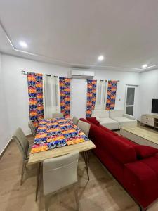 a living room with a table and a red couch at Tchaopremium in Lomé