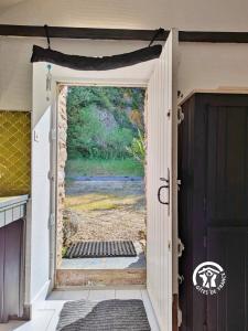 an open door with a view of a yard at La Roche des Eaux Vives, 2 personnes in Fromentières