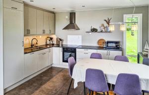 a kitchen with a white table and purple chairs at Valvik in Tansøy