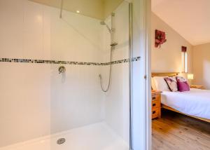 a bathroom with a shower and a bed at Meadows End Lodges in Cartmel