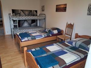 a bedroom with two bunk beds and a chair at Ferienwohnung Andy in Bremerhaven
