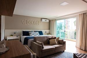 a bedroom with a bed and a couch in front of a bed at Prive Thermas Hotel by WAM Experience in Caldas Novas +47 photos