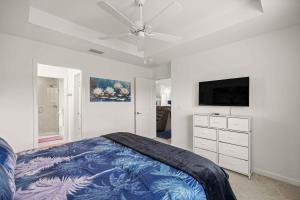 a bedroom with a bed and a flat screen tv at Spacious 3BR - Sleeps 7 - King Bed - Lanai in Okahumpka