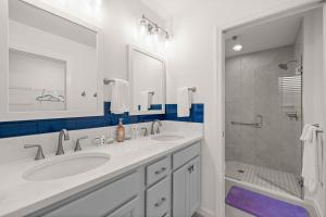 a white bathroom with two sinks and a shower at Spacious 3BR - Sleeps 7 - King Bed - Lanai in Okahumpka +28 photos