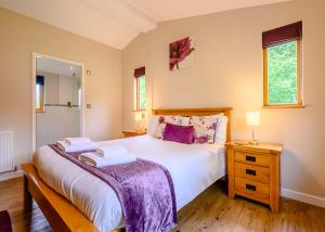a bedroom with a bed with two towels on it at Meadows End Lodges in Cartmel