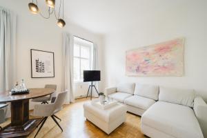 a living room with a white couch and a table at GH Luxury Apartments Graz, Gösser Haus in Graz
