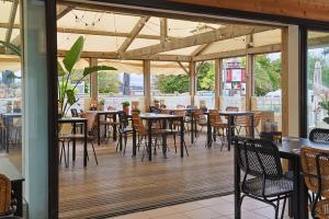 a restaurant with tables and chairs on a deck at Camping RCN Port l'Epine in Trélévern
