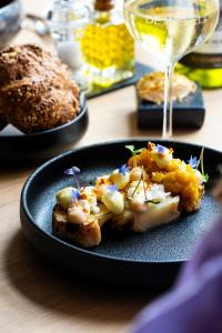 a plate of food on a table with a glass of wine at Hotel de Wereld in Wageningen