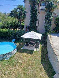 a patio with an umbrella next to a swimming pool at Apartments Suzana in Čapljina