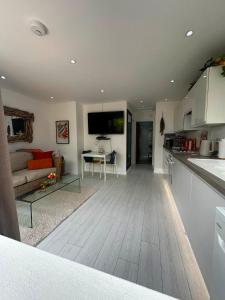 a kitchen and a living room with a table at Ocean Drive Deluxe Apartment with use of the Day time Beach Hut in Brean