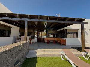 a patio with a wooden pergola and a table at Villa Tuco in Costa Teguise