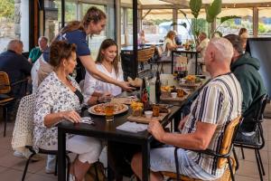 a group of people sitting at a table eating food at Camping RCN Port l'Epine in Trélévern +28 photos