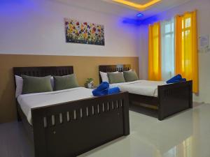 two beds sitting next to each other in a room at Jade Resort - Bauang, La Union in Bauang +3 photos