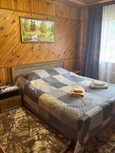 a bedroom with a bed with two towels on it at Berizka in Yaremche