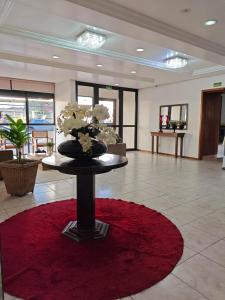 eine Lobby mit einer Blumenvase auf einem Tisch in der Unterkunft River Hotel in Uruguaiana + 77 Fotos