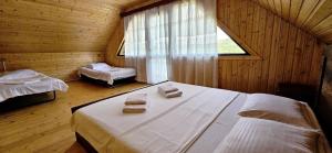 a bedroom with two beds and a window with towels on them at კერა მთაში Kera Mtashi in Ambrolauri