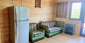 a kitchen with two chairs and a refrigerator in a room at კერა მთაში Kera Mtashi in Ambrolauri