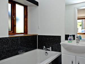 a bathroom with a sink and a bath tub at Bluetit Cottage in Kings Nympton