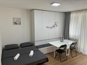 a bedroom with a bed and a table with chairs at Apartment S&S Tomislavgrad in Tomislavgrad