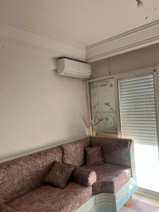 a couch sitting in a room with a window at Dar El vague in Hiboun