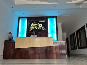 a man standing at a podium in a room at Hotel Satyaki Orchid in Katra