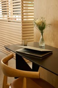 a black desk with a vase of flowers and a table with a chair at Maison Honnel in Paris