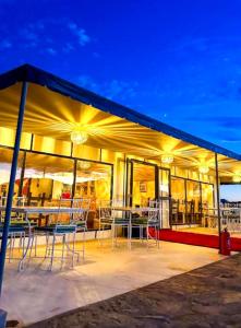 a patio with tables and chairs in a building at Majestic Dunes Luxury Camp in Merzouga